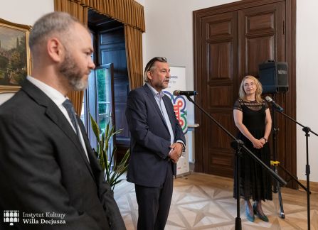 fotografia. otwarcie wystawy milana lukacsa w willi decjusza. dyrektorka instytutu kultury willa decjusza dominika kasprowicz przemawia do mikrofonu. obok niej autor wystawy.